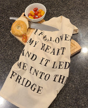 Load image into Gallery viewer, This Flour Sack style, 100% cotton tea towel has a screen-printed design, is washable and reusable. Machine wash gentle cycle. Measures: 20" w x 28" Quote on towel: "I Followed my heart and it led me into the fridge"