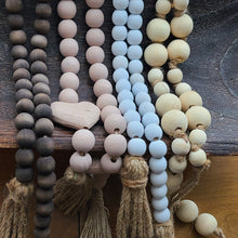 Load image into Gallery viewer, A simple must have coffee table styling piece, these wooden beads add a touch of feel-good style to your living space. Inspired by Mala beads used for prayer and meditation, they encourage mindfulness, peace, and clarity. Dimensions: 48"L x 0.5"W x 0.5"H Materials: Paulownia Wood, Jute rope tassels - Carved from paulownia wood and finished with a brown wash
