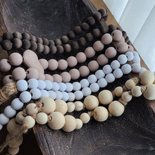 Load image into Gallery viewer, A simple must have coffee table styling piece, these wooden beads add a touch of feel-good style to your living space. Inspired by Mala beads used for prayer and meditation, they encourage mindfulness, peace, and clarity. Dimensions: 36"L x 1"W x 1"H Materials: Paulownia Wood, Jute rope - Carved from paulownia wood and finished with a natural wash