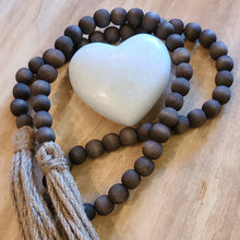 Load image into Gallery viewer, A simple must have coffee table styling piece, these wooden beads add a touch of feel-good style to your living space. Inspired by Mala beads used for prayer and meditation, they encourage mindfulness, peace, and clarity. Dimensions: 48"L x 0.5"W x 0.5"H Materials: Paulownia Wood, Jute rope tassels - Carved from paulownia wood and finished with a brown wash