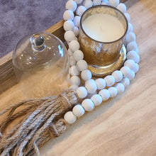 Load image into Gallery viewer, A simple must have coffee table styling piece, these wooden beads add a touch of feel-good style to your living space. Inspired by Mala beads used for prayer and meditation, they encourage mindfulness, peace, and clarity. Dimensions: 48"L x 0.5"W x 0.5"H Materials: Paulownia Wood, Jute rope tassels - Carved from paulownia wood and finished with a white wash