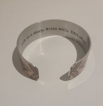 Load image into Gallery viewer, We have picked some of our favourite pieces and paired them with an inspirational saying that resonates with us.  Quote inside:  "Life is a story. Write well. Edit often."  Made of aluminum each cuff is hypo-allergenic, lead and nickel free, with no toxic finishes. Everything is printed with a permanent dye which gives a nice vibrant finish.   Cuffs are super light weight and adjustable allowing them to be molded to fit most sizes.   Each cuff is 3/4" thick