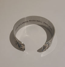 Load image into Gallery viewer, We have picked some of our favourite pieces and paired them with an inspirational saying that resonates with us. We know you will love this piece as much as we do.   Quote inside:  "Life is a story. Write well. Edit often."  Made of aluminum each cuff is hypo-allergenic, lead and nickel free, with no toxic finishes. Everything is printed with a permanent dye which gives a nice vibrant finish.   Cuffs are super light weight and adjustable allowing them to be molded to fit most sizes.   Each cuff is 3/4" thic