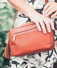 Load image into Gallery viewer, This Tan Holly crossbody bag is the ultimate accessory.   Stylish, yet practical.  Great for travel and you will be amazed at how much fits in there.  Features:  1 Zip Pocket 1 Flat Pocket Internal lining - Black/White Stripe Strap: 110cm Adjustable Detachable Closure: Zip Closure Material: Suedette Vegan Leather  Hardware: Light Gold  Dimensions: W24 x H16 x D8 cm