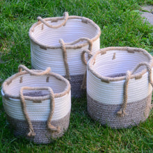 Load image into Gallery viewer, Add these beautiful storage baskets to your living space.  These two-tone cotton rope baskets are designed in natural shades of beige and brown. Jute rope handles at the sides make it easy to move the baskets around any room.   3 sizes to choose from:  Small:  8" Diameter Medium:  9.5" Diameter Large:  10.5" Diameter Get creative and use them as the base for an amazing gift basket filled with our great products.  Material:  Cotton, Jute.