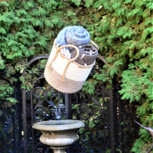 Load image into Gallery viewer, Large woven braided basket - 10.5" diameter. Shown with 2 wool blankets inside being thrown in the air