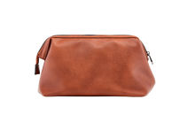 Load image into Gallery viewer, The Gilbert Men’s Toiletry Case is the perfect men’s travel accessory. Designed to fit his toiletries with ease and constructed with quality vegan leather, it is an ideal gift for the men in your life. 2 Colours to choose from: Black Tan Pair it with the Sinatra Toiletry Case for a set that has him covered! Internal features: 1 Zip Pocket Lining: Nylon Closure: Secure Zip Material: Vegan Leather Hardware: Gun Metal Dimensions: W25.5 x H16.5 x D9cm. Shown: Tan