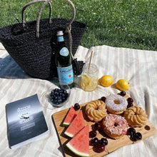 Load image into Gallery viewer, Classic black handbag with its thick handle and high-quality structure. It features a removable tassel made of thick jute rope and wooden beads. Use the tassel as a home accent, a doorknob hanger, a wall hanging, or over another bag. Hand-woven by independent Balinese artisans in a fair-trade environment, each bag is crafted using sustainably-harvested mendong grass. Size: 20" L x 6.5" W x 16" H Material: Handbag: Mendong grass; Tassle: Jute rope and wooden beads