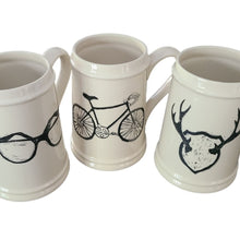 Load image into Gallery viewer, Add to your drinkware collection with these unique beige ceramic beer steins.  Perfect for entertaining on the patio or cottage deck, or chilling in front of the tv.  Pair them with your favourite bottle for a great Father's Day, Birthday or Just Because gift.  3 styles to choose from:  Antlers Sunglasses Bicycle Capacity:  18oz  Material:  Ceramic