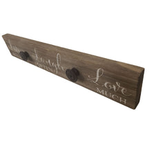 Load image into Gallery viewer, This farmhouse style painted wood plaque with printed "Live Well Laugh Often Love Much" sentiment is the perfect adornment for any home, and has added iron knobs perfect for hanging hats, dog leashes and handbags.  Hang it in your foyer, kitchen, familyroom or hallway so everyone can see it and use it.  Makes a great hostess, mother's day or just because gift too.  Size: 16" x 2.5" x .75"  Material: Pine wood/Iron