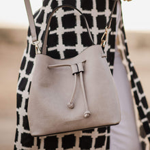 Load image into Gallery viewer, Complete with a drawstring closure, the Sasha is perfect for your next brunch with the girls, or a day out on the town.  Wear it your way and sling over your shoulder for a more casual look or carry by her top handle for a dressier option.  Features:  1 Slip Pocket Internal lining - Vegan Leather Extension strap: 114-128cm Adjustable Detachable Closure: Magnetic Clasp with Draw String Material: Vegan Leather  Hardware: Light Gold  Dimensions: W26 x H23 x D14 cm