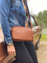 Load image into Gallery viewer, This Tan Holly crossbody bag is the ultimate accessory.   Stylish, yet practical.  Great for travel and you will be amazed at how much fits in there.  Features:  1 Zip Pocket 1 Flat Pocket Internal lining - Black/White Stripe Strap: 110cm Adjustable Detachable Closure: Zip Closure Material: Suedette Vegan Leather  Hardware: Light Gold  Dimensions: W24 x H16 x D8 cm
