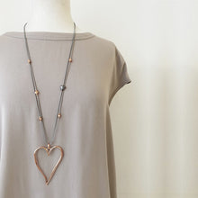 Load image into Gallery viewer, We are so in love with this beautiful big and shiny rose gold large heart pendant necklace. With its beaded adjustable cord, it&#39;s definitely an eye-catcher.  So versatile, it can be worn with any outfit for any occassion.  *Adjustable. Necklace shown on mannequin
