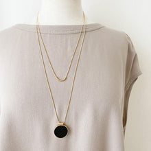 Load image into Gallery viewer, double chain gold necklace has a beautiful black resin pendant. Necklace is adjustable and is shown on mannequin
