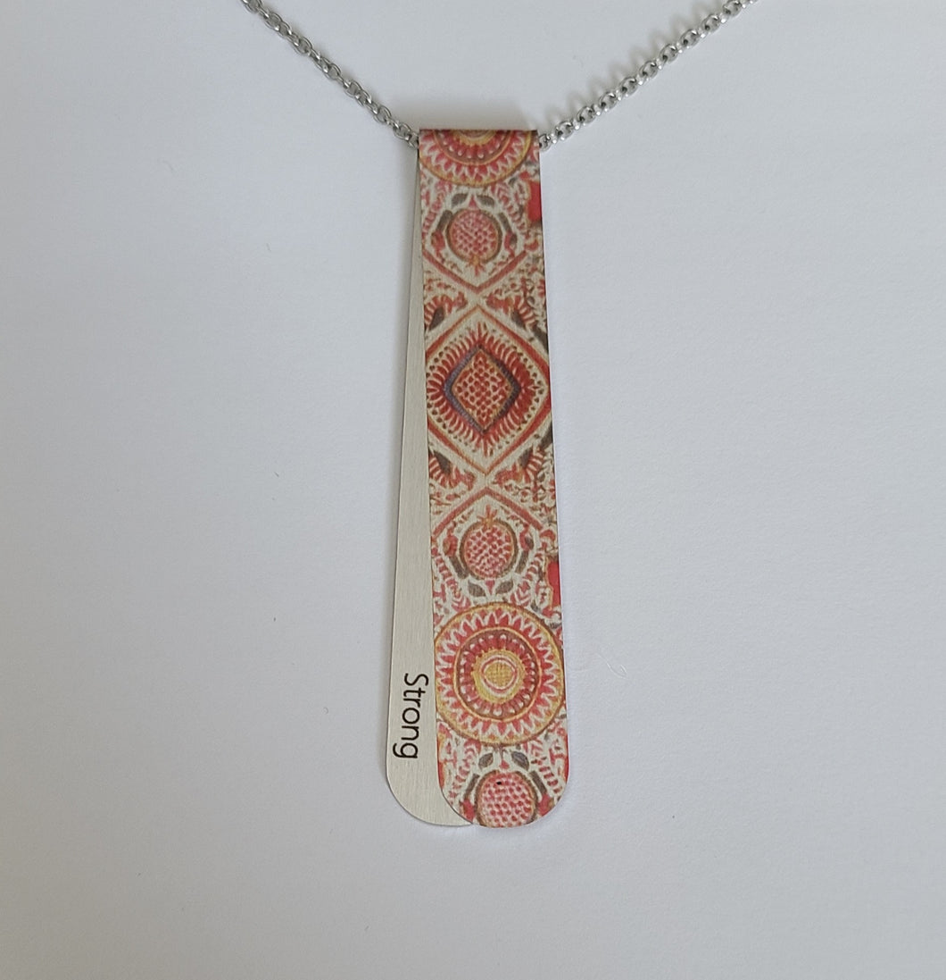 The Caraway necklace has a vintage middle eastern vibrant pattern, with hits of warm green and ochre.  The off centre bend allows for the affirmation word 