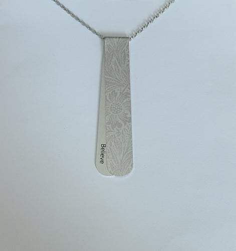 The Etched Fostoria layered necklace has silver on silver tones with floral pattern.  The off centre bend allows for the affirmation word 