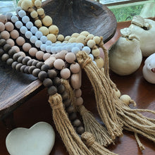 Load image into Gallery viewer, This beaded pink heart garland makes an easy and textural addition to your home décor. Blessing Beads are a lovely way to add a little sentiment to your space and a fun touch to your favorite piece. Drape it over your chair, have it spilling onto your coffee table or hang them from an armoire. They are used to bring good wishes, healing and luck. · Dimensions: 1.96&quot;L x 0.59&quot;W x 33.4&quot;H Materials: Paulownia Wood, Jute Carved from paulownia wood and finished with a light pink wash. 
