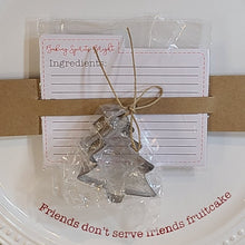 Load image into Gallery viewer, Christmas Cookie Platter 3-piece Set.  The round ceramic plate features a raised beaded rim and debossed sentiment &quot;Friends don&#39;t serve friends fruitcake&quot;.   Makes a perfect holiday or hostess gift - fill it with your favourite cookies for an extra special treat!  Set Includes:  (1) Large Ceramic Platter (1) Metal Tree Cookie Cutter (10) Cardstock Recipe Cards Features:  Ceramic Hand wash Measures 12&quot; diameter 5 lb. capacity
