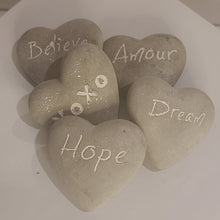 Load image into Gallery viewer, These fun and sentimental heart shaped stones are perfect for expressing ones feelings of love, hope, dream and belief. Comes in an assorted set of 5. Give all 5 to that special someone, or spread the love and give one to all your special someones. Don&#39;t forget to keep one as a reminder to yourself. Each Set Includes 5 Stones*: Believe Hope Dream Amour XOXO Materials: Cement Dimensions: 2.7&quot;L x 2.5&quot;W (each stone) Fragile in nature; handle with care *Must be purchased as a set of 5 assorted stones.
