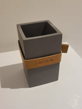 Load image into Gallery viewer, Sleek and stylish, this cute pen holder isn&#39;t just for pens.  You can use it for virtually anything!  With a beautiful &quot;Just Love&quot; sentiment, perfect for the home office, kitchen counters and bathrooms.    Size:  2.5&quot; W x 4.5&quot; H x 2.5&quot; D  Material: Cement/Leather Strap  **Spot Clean Only
