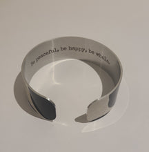 Load image into Gallery viewer, We have picked some of our favourite pieces and paired them with an inspirational saying that resonates with us. We know you will love this piece as much as we do.   Quote inside:  &quot;Be peaceful, be happy, be whole.&quot;  Made of aluminum each cuff is hypo-allergenic, lead and nickel free, with no toxic finishes. Everything is printed with a permanent dye which gives a nice vibrant finish.   Cuffs are super light weight and adjustable allowing them to be molded to fit most sizes.   Each cuff is 3/4&quot; thick.
