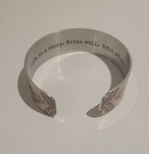 Load image into Gallery viewer, We have picked some of our favourite pieces and paired them with an inspirational saying that resonates with us.  Quote inside:  &quot;Life is a story. Write well. Edit often.&quot;  Made of aluminum each cuff is hypo-allergenic, lead and nickel free, with no toxic finishes. Everything is printed with a permanent dye which gives a nice vibrant finish.   Cuffs are super light weight and adjustable allowing them to be molded to fit most sizes.   Each cuff is 3/4&quot; thick
