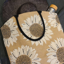 Load image into Gallery viewer, Make a statement this summer on daytime trips or holiday adventures with our beautiful burlap beach tote.  This spacious bag has ample room for all of your essentials.  Styled with hand-woven terrycloth sunflower motifs, this beach bag provides functionality while serving a fashionable look to passers by.  This summer beach tote is a must have to venture off to the beach, cottage, boat cruise, picnic or weekend getaway in style!  Material: Burlap  Dimensions: W21&quot; x H18&quot; x D6&quot;
