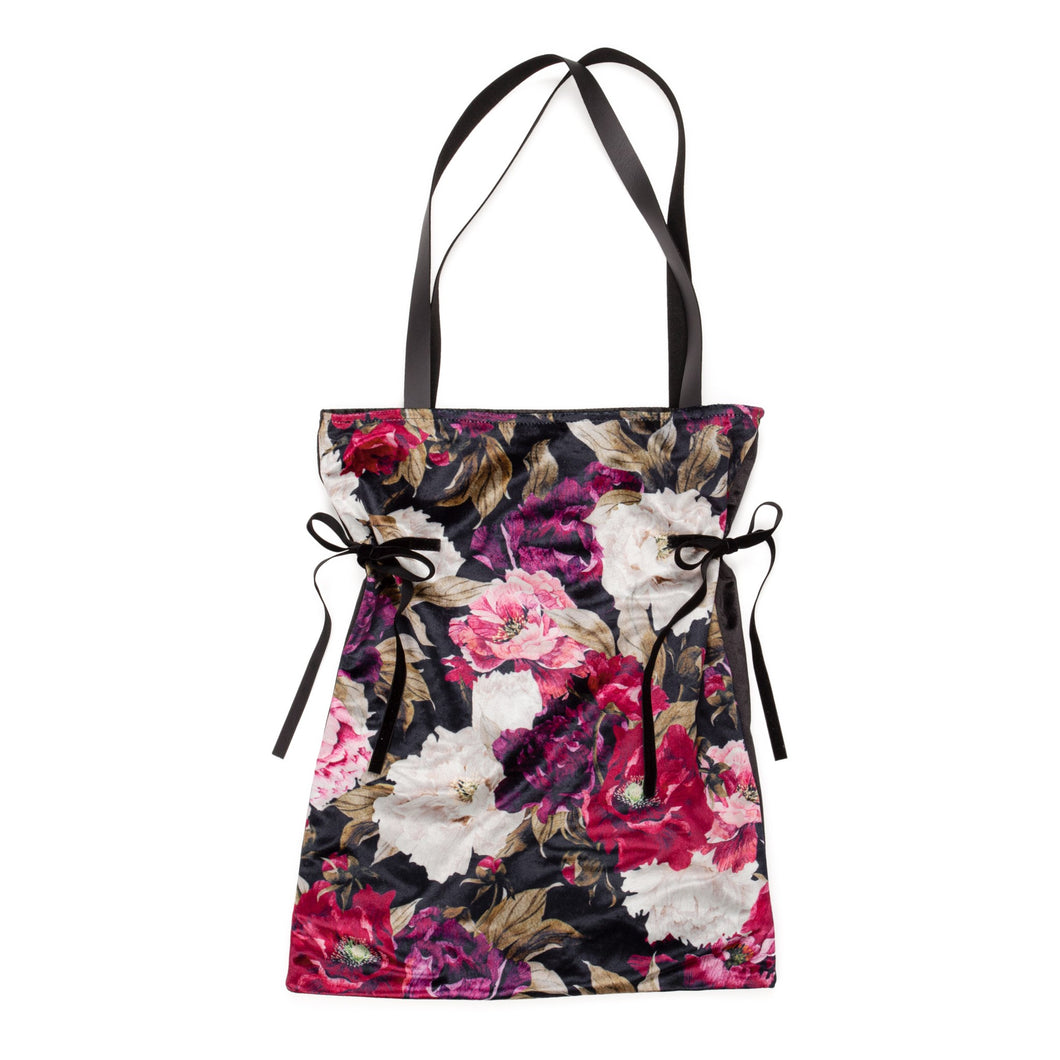 Arrive in style with this satin-lined bohemian black and floral velour tote bag. Perfect for carrying your shoes, groceries, laptop, etc.  Super soft and features two ties on the sides to cinch it when necessary.  Make your next gift extra special by swapping the traditional gift bag for this luxurious tote instead!  Measures: 18