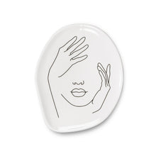Load image into Gallery viewer, Add an artistic touch to your keepsakes, coins and more with this Face Trinket Plate. Crafted out of porcelain, the subtle Expressionistic lines of a woman’s visage also gives this unique plate its shape.  A stylishly unexpected way to store your jewelry or simply keep keys and other knick-knacks close at hand when needed.  Will definitely make a statement to any decor.  These plates can be used as tea or dessert dishes. Size:  Approximately 5 x 4&quot;
