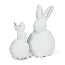 Load image into Gallery viewer, These adorable Sitting Bunny figurines make a delightful finishing touch for all your Easter decor. The simple yet elegantly white colour and stylized shape of the rabbits are the perfect complement to any spring decor, especially colourful flowers, eggs and more.  Perfect for any mantel, countertop, tabletop or coffee table.    Each Set Includes:  (1) Medium Bunny - 5.5&quot;H (1) Small Bunny - 4&quot; H Material: Cement
