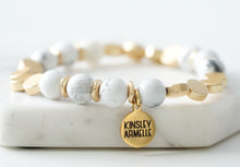 Load image into Gallery viewer, The Pepper Amari Beaded Bracelet is comprised of White Howlite stone beads spaced evenly with decorative gold flat disc embellishments. The Pepper Amari is perfect on its own, but it also completes the look of, and exquisitely complements, the other bracelets featured in the Lennox Stack. Exclusively from Kinsley Armelle.  Details:  Style: Beaded Material: White Howlite and Metal Size: 6.5 - 8 Inch Circumference
