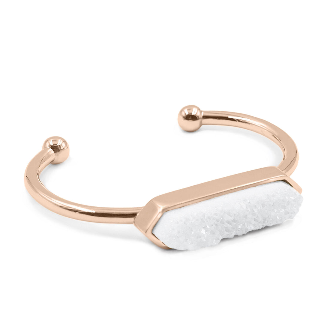 The Quartz Metal Cuff Bangle in Rose Gold features a raw white quartz stone on a smooth rose gold ion-plated stainless steel cuff. The stones are rigid rocks to add that extra flare to your stack or outfit for the night. This bracelet is featured as part of the Lainey Stack , Exclusively from Kinsley Armelle.  Details:  Style: Bangle Material: White Quartz and 18K Rose Gold Ion Plated Stainless Steel Size: 6.5 - 8 Inch Circumference