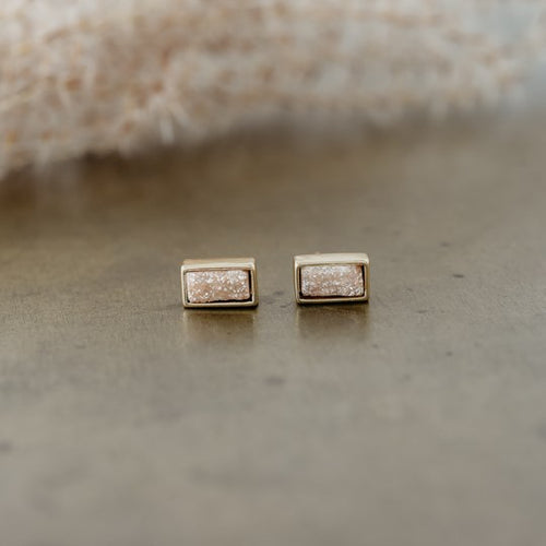 These simple studs draw attention with its drop of sunlight sparkle.  They have a small and delicate presence, and will shine with any of your outfits for any occasion.  Details:  Druzy quartz studs Disc backing Hypoallergenic Nickel/ lead free 3 coats anti tarnish. Shown: Champagne