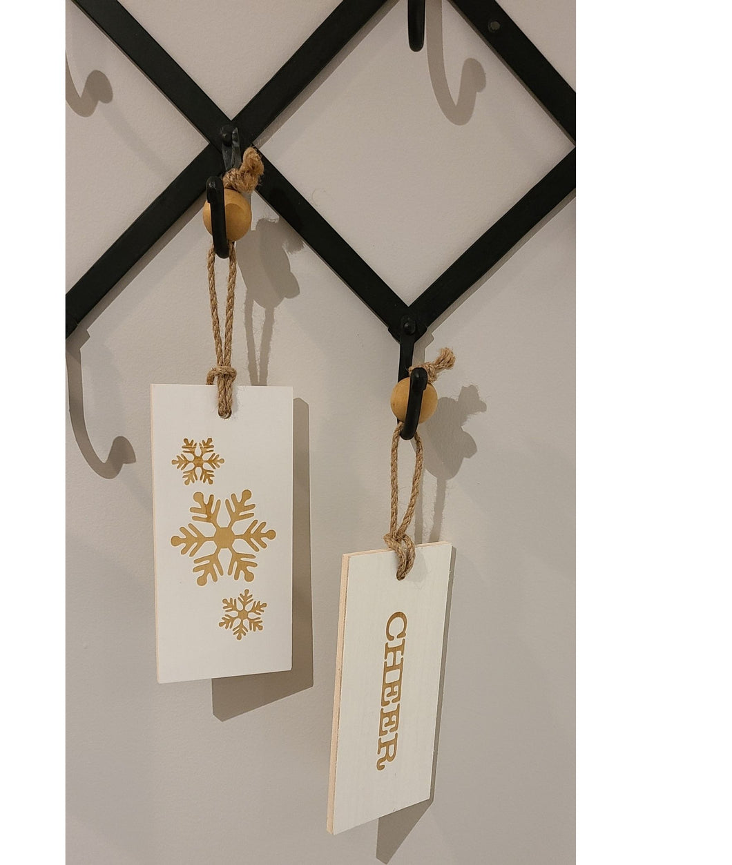 These fun and whymsical Christmas Hangers will create the perfect welcome this holiday season. With a Christmas Message on one side, and a Winter Symbol on the other, this white and gold decor will look beautiful in any room. Put it anywhere...doorknobs, walls, mantles...and you can even use it as ornaments on your tree. 2 Styles to choose from: Cheer Noel. Size: 7.5 x 3.5 x .25