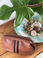 Load image into Gallery viewer, The Gilbert Men’s Toiletry Case is the perfect men’s travel accessory. Designed to fit his toiletries with ease and constructed with quality vegan leather, it is an ideal gift for the men in your life. 2 Colours to choose from: Black Tan Pair it with the Sinatra Toiletry Case for a set that has him covered! Internal features: 1 Zip Pocket Lining: Nylon Closure: Secure Zip Material: Vegan Leather Hardware: Gun Metal Dimensions: W25.5 x H16.5 x D9cm. Shown: Tan
