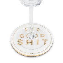 Load image into Gallery viewer, Your guests won’t have to wonder what you’re serving them with this cheeky “The Good Shit” Coaster. Crafted out of ceramic and cork with elegant gold lettering, this coaster will definitely make your guests feel like they’re the privileged few.  Size:  4&quot; Diameter Material:  Ceramic/Cork Colour:  White/Gold 

