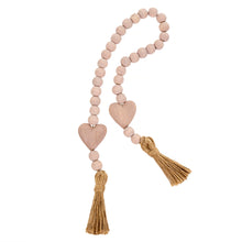 Load image into Gallery viewer, This beaded pink heart garland makes an easy and textural addition to your home décor.  Blessing Beads are a lovely way to add a little sentiment to your space and a fun touch to your favorite piece. Drape it over your chair, have it spilling onto your coffee table or hang them from an armoire. They are used to bring good wishes, healing and luck. ·  Dimensions: 1.96&quot;L x 0.59&quot;W x 33.4&quot;H  Materials: Paulownia Wood, Jute Carved from paulownia wood and finished with a light pink wash
