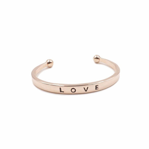 The Love Metal Cuff Bracelet in Rose Gold features a simplistic bangle with the word LOVE inscribed on the outside. Wear this bangle on its own to make a simple statement or as part of the Lainey Stack to make the perfect stack. Exclusively from Kinsley Armelle.   Details:  Style: Cuff Material: 18K Rose Gold Ion Plated Stainless Steel Size: 6.5 - 8 Inch Circumference