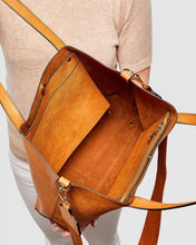 Load image into Gallery viewer, The Nutmeg Nevada Bag is a great tote style which can double as a laptop or work bag. Featuring a luxurious suedette lining, this shoulder bag is spacious and functional with enough room to carry all your essentials and more! Features: 2 Slip Pockets 1 Zip Pocket Feet on Base Internal Lining: Suedette Strap: Height 25cm Extension Strap: Detachable Webbing 41cm Magnetic Clasp Material: Vegan Leather Hardware: Light Gold Dimensions: H31 x W41 x D11 cm. Shown: Inside bag

