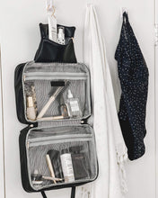 Load image into Gallery viewer, The Black Emma hanging toiletry case is the perfect travel companion with waterproof sealed compartments and a hook for convenient hanging.     Pair it with the Bardot cosmetic case for an Exclusive Bundle!  Internal Features:  Hanging Hook with Zip Compartment 2 Zip Pockets Lining: Black/White Stripe External Features:  Black Zip Pocket Secure Zip Material: Vegan Leather  Hardware: Silver  Dimensions: H21 x W28 x D9 cm
