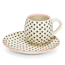 Load image into Gallery viewer, Brighten your morning coffee or tea with this stylish Polka Dot Ball Mug. Crafted out of stoneware, this hand-painted, capacious ball-shaped mug features a contemporary graphic polka dot pattern, offset by subtle pink trim around its rim. Dishwasher and microwave safe.  Matching dessert plate also available.  Size:  5&quot; L  Material:  Stoneware  Capacity:  16oz  Colour:  Ivory/Black. shown with matching saucer.
