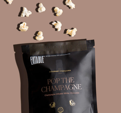 Pop The Champagne Infused Gourmet Popcorn (40 gram bag) by EATABLE.  Kettle popped whole grain popcorn coated in a smooth, premium Belgian white chocolate. Sprinkled with Champagne-infused sugar crystals that literally 
