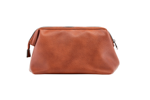Load image into Gallery viewer, The Gilbert Men’s Toiletry Case is the perfect men’s travel accessory. Designed to fit his toiletries with ease and constructed with quality vegan leather, it is an ideal gift for the men in your life. 2 Colours to choose from: Black Tan Pair it with the Sinatra Toiletry Case for a set that has him covered! Internal features: 1 Zip Pocket Lining: Nylon Closure: Secure Zip Material: Vegan Leather Hardware: Gun Metal Dimensions: W25.5 x H16.5 x D9cm. Shown: Tan
