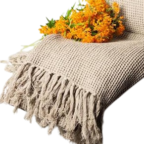This beautiful Throw Blanket has a classic waffle weave pattern adorned with whimsical fringes.  Light, yet cozy.  Matches perfect with any decor.  Size:  68 × 52 in  Colour:  Taupe  Material:  Cotton