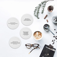 Load image into Gallery viewer, Authentic Coasters are the perfect accompaniment to your favourite beverage.    Each coaster is made of porcelain with a matte finish. The back side is finished in cork.   Each coaster is 3.5&quot; round  Set of 4 coasters each with a different Authentic Quote:  Take time to do what makes your soul happy. Beauty begins the moment you decide to be yourself. -Coco Chanel Be yourself. Everyone else is taken. -Oscar Wilde Why fit in when you were born to stand out?
