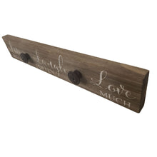 Load image into Gallery viewer, This farmhouse style painted wood plaque with printed &quot;Live Well Laugh Often Love Much&quot; sentiment is the perfect adornment for any home, and has added iron knobs perfect for hanging hats, dog leashes and handbags.  Hang it in your foyer, kitchen, familyroom or hallway so everyone can see it and use it.  Makes a great hostess, mother&#39;s day or just because gift too.  Size: 16&quot; x 2.5&quot; x .75&quot;  Material: Pine wood/Iron
