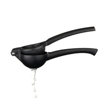 Load image into Gallery viewer, Matte Black Citrus Press by Viski for lemons and limes.  Showing lime juice flowing out

