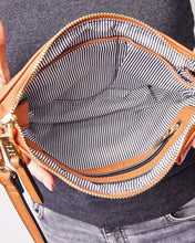Load image into Gallery viewer, This Tan Holly crossbody bag is the ultimate accessory.   Stylish, yet practical.  Great for travel and you will be amazed at how much fits in there.  Features:  1 Zip Pocket 1 Flat Pocket Internal lining - Black/White Stripe Strap: 110cm Adjustable Detachable Closure: Zip Closure Material: Suedette Vegan Leather  Hardware: Light Gold  Dimensions: W24 x H16 x D8 cm
